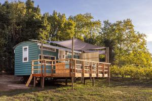 a green tiny house with a tent in a field at The Huts - Glamping at Caledon Grace in Caledon