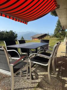 a table and chairs sitting under an umbrella at Anzère appartement de vacances calme et sympa in Anzère