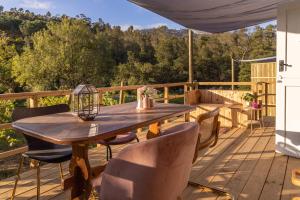 a wooden deck with a wooden table and chairs at The Huts - Glamping at Caledon Grace in Caledon +39 photos
