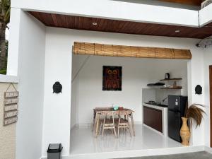 a kitchen with a table in the middle of a house at Peony Villa Lovina in Lovina