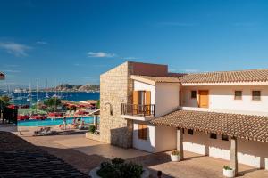a view of a building and a swimming pool at Club Esse Residence Capo D'orso in Palau