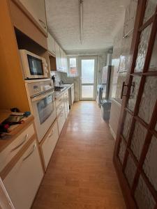 a kitchen with white appliances and a wooden floor at Hawkins Guesthouse in Milton