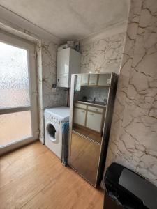 a kitchen with a refrigerator and a washing machine at Hawkins Guesthouse in Milton
