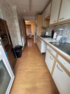 a kitchen with white cabinets and a wooden floor at Hawkins Guesthouse in Milton