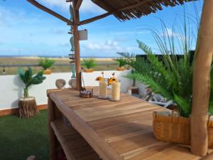 a wooden table with two figurines on top of it at Villadunas - with Luxury Hot Tub and Tiki Roof Top Bar in Corralejo +34 photos