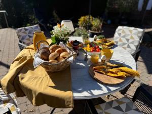 a table with a basket of bread and vegetables on it at Schiller Ferienwohnung, Pool, Nideggen, Eifel in Nideggen +76 photos