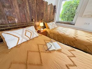 a bedroom with two beds and a window at Schiller Ferienwohnung, Pool, Nideggen, Eifel in Nideggen