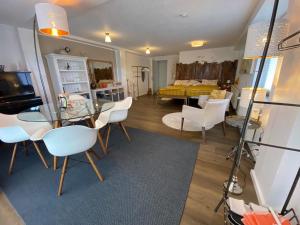 a living room with a glass table and white chairs at Schiller Ferienwohnung, Pool, Nideggen, Eifel in Nideggen
