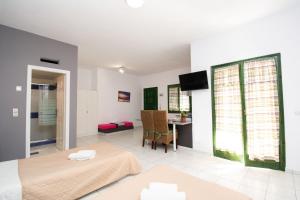 a room with a bed and a table with a television at Aquarius Apartments "by Checkin" in Agia Pelagia +20 photos