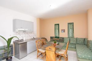 a kitchen and dining room with a table and a couch at Aquarius Apartments "by Checkin" in Agia Pelagia