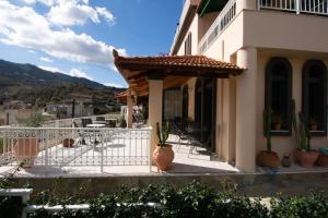a house with a porch with potted plants on it at Aquarius Apartments "by Checkin" in Agia Pelagia