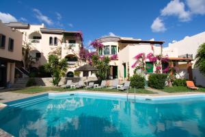 a swimming pool in front of a house at Aquarius Apartments "by Checkin" in Agia Pelagia