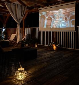 a stage with a large screen with a presentation at Między lasem a wsią-kameralne domki dla dorosłych-jacuzzi i śniadanie w cenie in Grzybowo