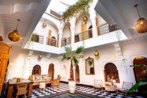 a lobby of a building with a palm tree in the middle at Riad LallaBaya in Marrakesh