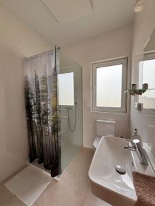a bathroom with a shower and a sink at Między lasem a wsią-kameralne domki dla dorosłych-jacuzzi i śniadanie w cenie in Grzybowo +23 photos