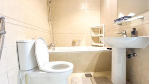 a bathroom with a white toilet and a sink at Spacious 2BR Apartment,3 Bathrooms, Near Mall in Abu Dhabi +3 photos