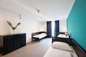 a bedroom with two beds and a blue wall at AR City Hotel Berlin in Berlin +79 photos