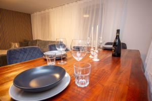 a wooden table with glasses and a bottle of wine at Mimi's Home in Dußlingen +52 photos