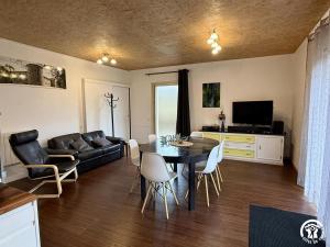 a living room with a table and a couch at Les ferrajals in Rouvenac
