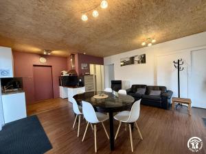 a living room with a table and chairs and a couch at Les ferrajals in Rouvenac