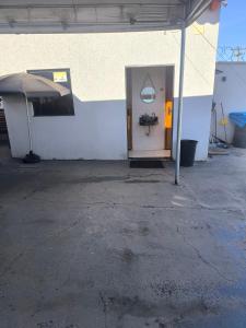 a white building with a door and an umbrella at Espaço de eventos dorneles in Senador Canedo +1 photo
