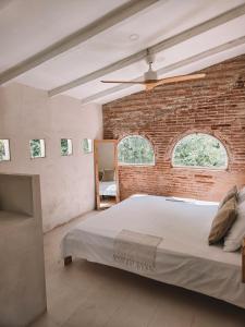a bedroom with a large bed and a brick wall at Casa Om in Dosríus +53 photos