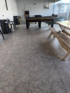 a ping pong table and a bench in a room at Espaço de eventos dorneles in Senador Canedo