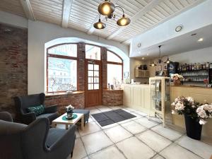 a living room with a couch and chairs and a window at Dvůr Stráň & Wellness in Karlovy Vary