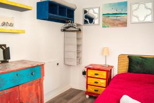 a bedroom with a bed and a dresser with a red blanket at High Flyers Kite House in Tarifa