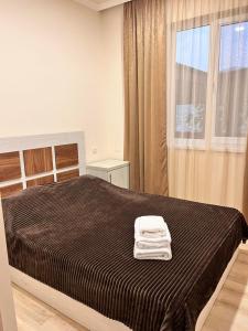 a bedroom with a bed with a black blanket and a window at Gogasar house in Ijevan +26 photos