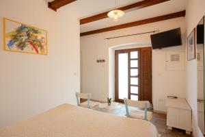 a bedroom with a bed and a tv in a room at Med oljkami Apartment in Koper