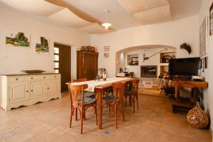 a kitchen with a table and chairs and a television at Med oljkami Apartment in Koper