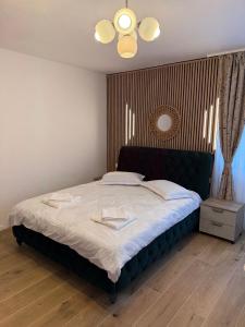 a bedroom with a large bed with a black headboard at Casa Romanța in Cehu Silvaniei