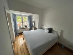 a bedroom with a white bed and a window at FEWO im Ortskern in Gudow