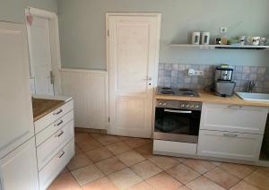 a kitchen with white cabinets and a stove top oven at FEWO im Ortskern in Gudow