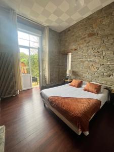 a bedroom with a large bed with a stone wall at Hôtel de Bretagne in Redon +64 photos