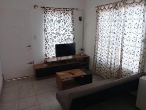 a living room with a couch and a television at Casa 1 in Rincon de los Sauces