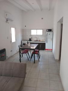 a kitchen with a table and chairs and a refrigerator at Casa 1 in Rincon de los Sauces