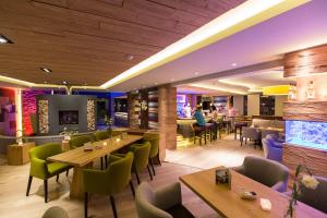 a restaurant with tables and chairs and a bar at Hotel Hochheide in Willingen