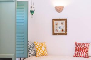 a room with blue shutters and a couch with pillows at Villa Matakia in Áno Potamiá