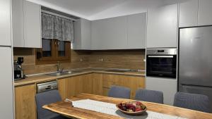 a kitchen with a table with a bowl of fruit on it at Διαμέρισμα με θέα - Sunset House Lemnos in Agios Ioannis Kaspaka