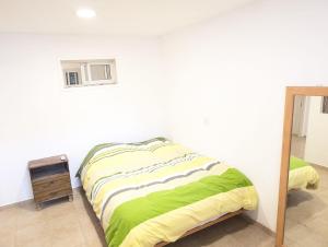 a white bedroom with a bed and a night stand at Old City Charm in Beer Sheva +8 photos