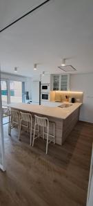a kitchen with a large kitchen island with chairs at EBEIA Casas Rurales IBEAS DE JUARROS (BURGOS) in Ibeas de Juarros