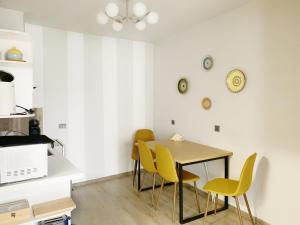 a dining room with a table and yellow chairs at Altavista mountain apartment in Samokov