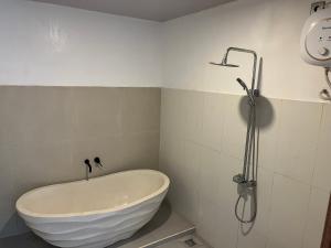 a bath tub in a bathroom with a shower at Peony Villa Lovina in Lovina +20 photos
