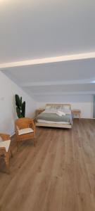 a bedroom with a bed and a couch and chairs at EBEIA Casas Rurales IBEAS DE JUARROS (BURGOS) in Ibeas de Juarros +12 photos