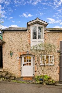 a brick house with a white door at Finest Retreats - Little Roost in Lyme Regis