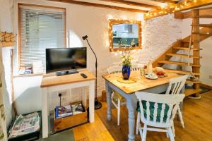 a room with a desk with a television and a staircase at Finest Retreats - Little Roost in Lyme Regis