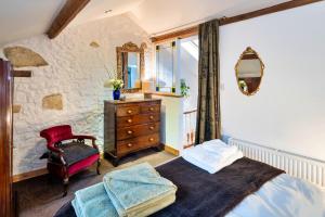 a bedroom with a bed and a dresser and a mirror at Finest Retreats - Little Roost in Lyme Regis