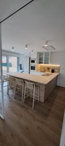 a kitchen with a large island with chairs in it at EBEIA Casas Rurales IBEAS DE JUARROS (BURGOS) in Ibeas de Juarros